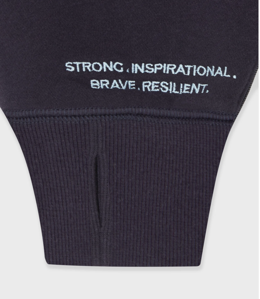 Wording on sweatshirt cuff with thumb hole reads Strong Inspirational Brave Resilient.